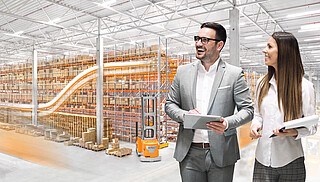 Two people standing in front of a warehouse and shelves